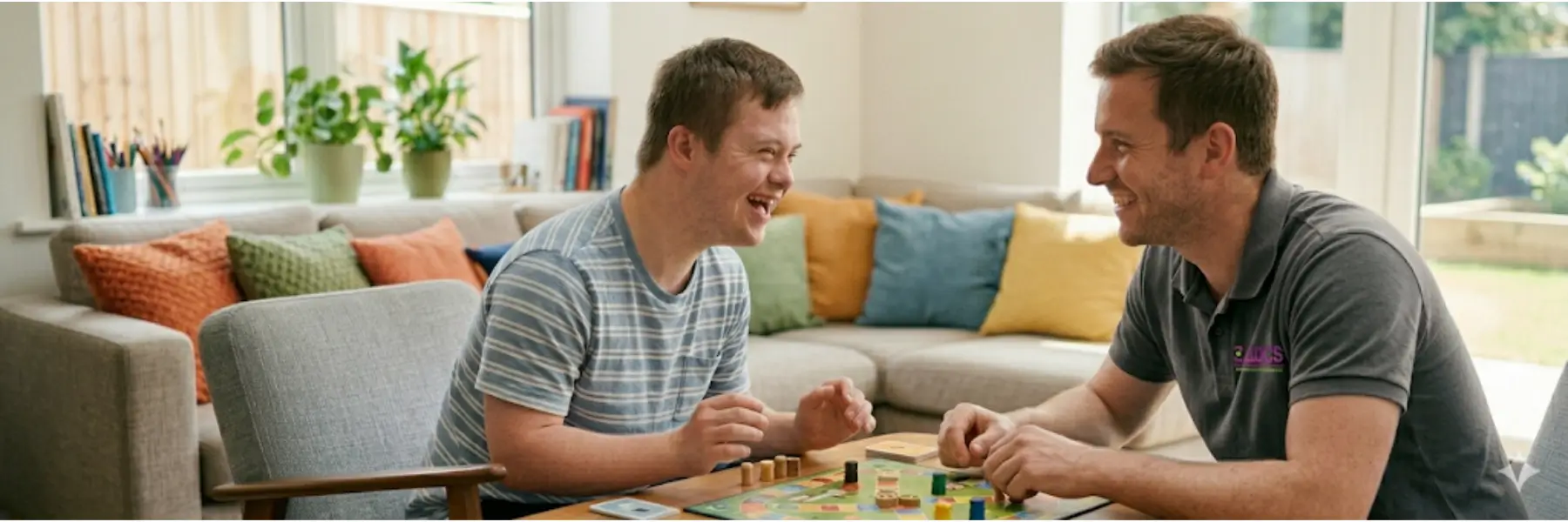 A young man and an adult male play a board game at a table